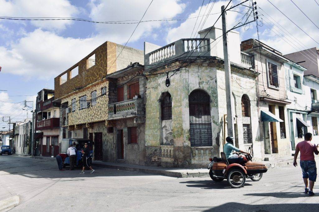 Streets of Santa Clara Cuba with colorful buildings and side car